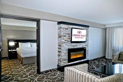 a hotel room with a bed and a fireplace at Crowne Plaza Kitchener-Waterloo by IHG in Kitchener