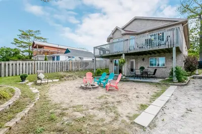 a yard with chairs and a house at Beach1 Riverfront Resort in Wasaga Beach