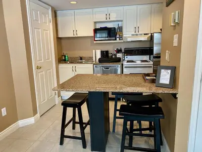 a kitchen with a counter and stools in a room at Quiet Hillside Studio - Wifi, Pool, Close to The Village in Blue Mountains