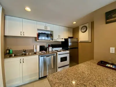a kitchen with stainless steel appliances and white cabinets at Quiet Hillside Studio - Wifi, Pool, Close to The Village in Blue Mountains