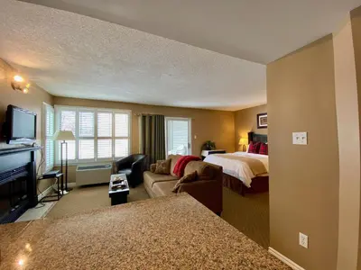 a hotel room with a bedroom and a bed at Quiet Hillside Studio - Wifi, Pool, Close to The Village in Blue Mountains
