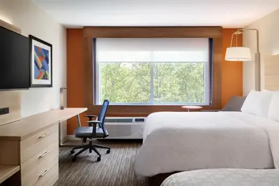 a hotel room with a bed and a desk and a window at Holiday Inn Express & Suites - Aurora by IHG in Aurora
