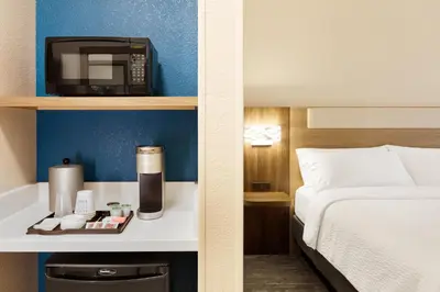 a hotel room with a bed and a microwave at Holiday Inn Express & Suites - Aurora by IHG in Aurora