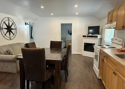 a kitchen and dining room with a table and a couch at Saga Resort in Wasaga Beach