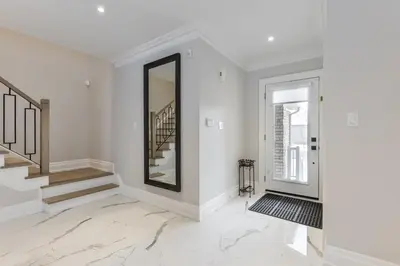 a white hallway with stairs and a mirror at Luxury Adventure, Rutherford Go station & Wonderland in Vaughan