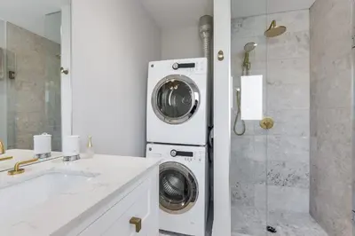 a washer and dryer in a bathroom with a shower at Luxury Adventure, Rutherford Go station & Wonderland in Vaughan