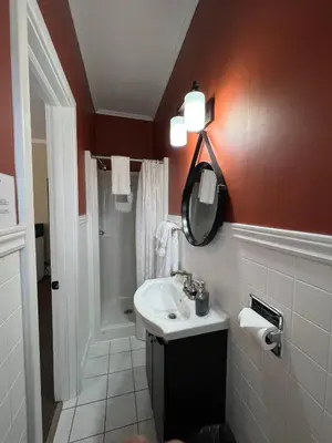 a bathroom with a white sink and a shower at Inn at the Falls in Bracebridge