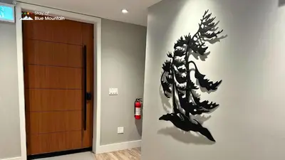 a wall with a black painting of a plant on a wall at Orchard Run Chalet in Blue Mountains