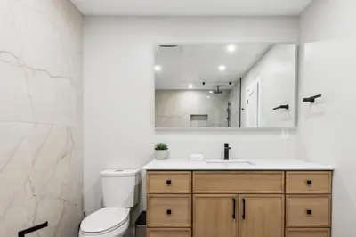 a bathroom with a sink and a toilet and a mirror at Ski In Out Chateau Ridge Chalet on Ski Run in Blue Mountains