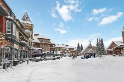 a snow covered street in a town with buildings at 2BR Slopeside in Chateau Ridge Blue Mountains in Blue Mountains