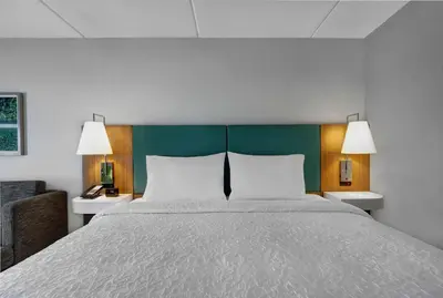 a bedroom with a large bed with a green headboard at Hampton Inn & Suites Belleville in Belleville
