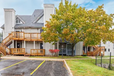 a large white house with a deck and a yard at Blue Mountain Hideaway at North Creek Resort in Blue Mountains