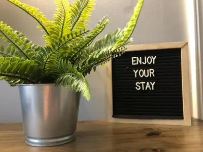 a potted plant on a table next to a blackboard at Blue Mountain Hideaway at North Creek Resort in Blue Mountains