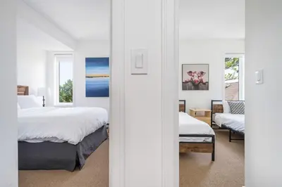 a bedroom with two beds and a living room at Ski in Ski Out Condo at Blue Mountain Close to Village in Blue Mountains
