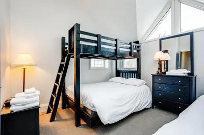 a bedroom with two bunk beds and a mirror at 2 Bdrm Ski In Ski Out Loft at Blue Mountain in Blue Mountains