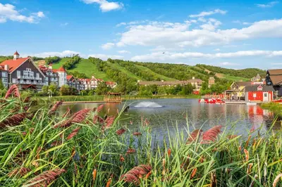 a town with a river with boats in the water at Blue Mountain Slopeside Chalet in Chateau Ridge in Blue Mountains