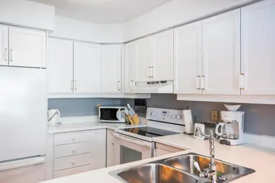 a kitchen with white cabinets and a sink at Blue Mountain Slopeside Chalet in Chateau Ridge in Blue Mountains