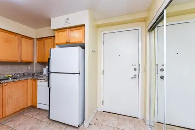 a kitchen with a white refrigerator and wooden cabinets at PlanURstay - Ideal 2 BR & 2BTH 3888 Duke of York Blvd in Mississauga