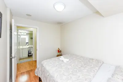 a white bedroom with a bed and a bathroom at PlanURstay - Ideal 2 BR & 2BTH 3888 Duke of York Blvd in Mississauga