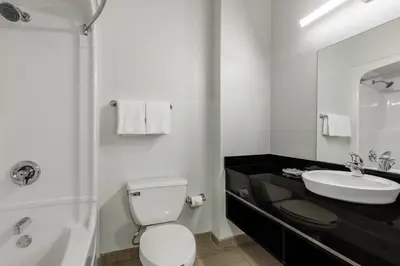 a bathroom with a white toilet and a sink at Studio 6 Toronto - Mississauga with Kitchenettes in Mississauga