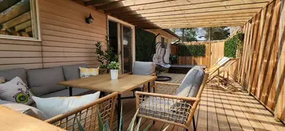 a patio with a table and chairs on a deck at Boho Cottage - Hot tub and close to Beach in Fort Erie
