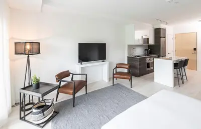 a living room with a table and chairs and a kitchen at Muskoka Bay Resort in Gravenhurst