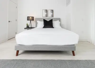 a large white bed in a white room with a white bedzinski at Muskoka Bay Resort in Gravenhurst