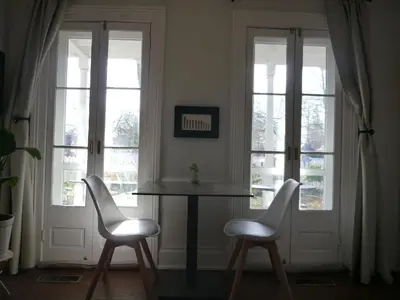 two chairs and a table in a room with windows at Harrogate House Inn in Niagara on the Lake