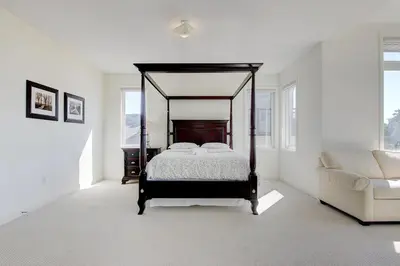 a bedroom with a canopy bed and a couch at Grand Waterfront Retreat under 1hr from Toronto in Bowmanville