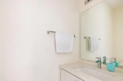 a white bathroom with a sink and a mirror at Grand Waterfront Retreat under 1hr from Toronto in Bowmanville