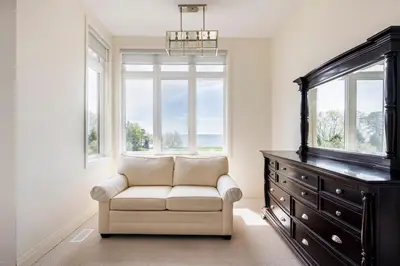 a living room with a couch and a dresser at Grand Waterfront Retreat under 1hr from Toronto in Bowmanville