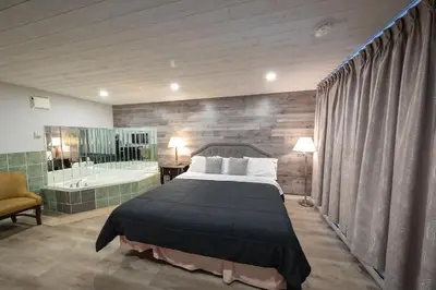 a bedroom with a large bed and a bath tub at Choice Inn by the falls in Niagara Falls