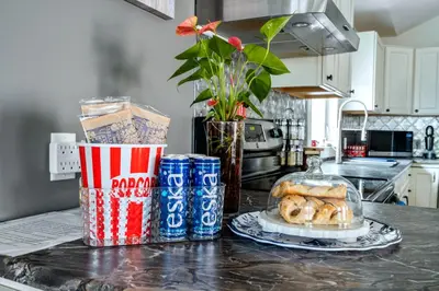 a kitchen counter with a plate of pastries and soda cans at Sandy Cove Cottage in Crystal Beach