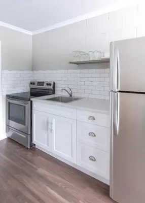 a kitchen with white cabinets and a stainless steel refrigerator at Boutique Suite #7 in Blue Mountains