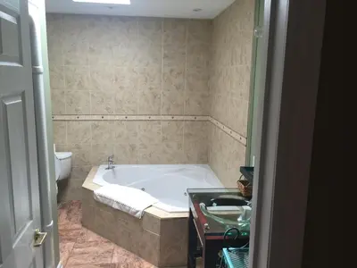 a bathroom with a bath tub and a toilet at Grey Rose Suites in Hanover
