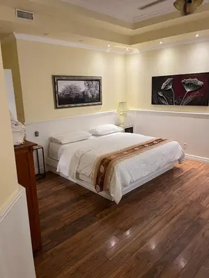 a bedroom with a large bed with a wooden floor at Grey Rose Suites in Hanover