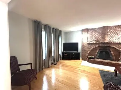 a living room with a fireplace and a television at Leslie in Wasaga Beach