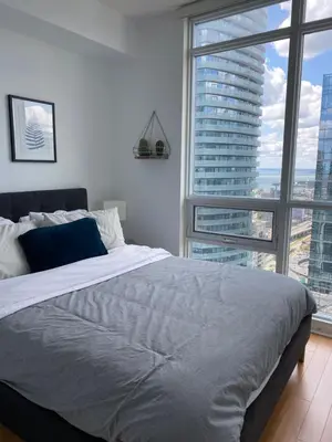 a bedroom with a large bed and a large window at Toronto CN Tower Maple Leaf Square Luxurious 2 Bedroom Condo in Toronto