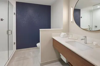 a bathroom with a sink and a mirror and a toilet at Fairfield by Marriott Inn & Suites Orillia in Orillia