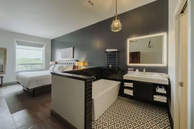 a bathroom with a bed and a tub and a sink at Mercer Hotel Downtown; BW Premier Collection in Stratford