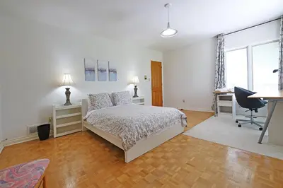 a white bedroom with a bed and a desk at Grand Villa Estate in Burlington