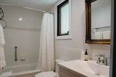 a bathroom with a sink and a toilet and a mirror at The Kent Motel in Niagara on the Lake