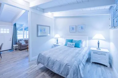 a white bedroom with a bed and two lamps at Boutique Suite #3 in Blue Mountains