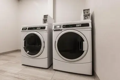 two washing machines sitting next to each other in a room at Holiday Inn Express & Suites - Welland in Welland