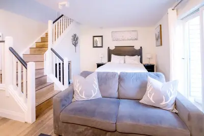 a living room with a blue couch in front of a bed at Loft with a view of Blue - Free Wifi, Linens and Towels Included in Blue Mountains