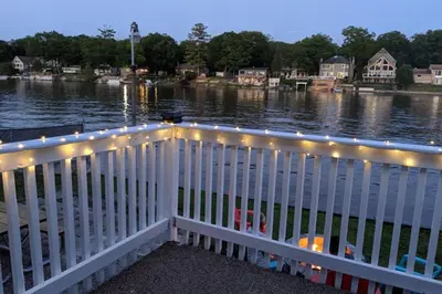 a white railing with lights on the water at Cottage with River Front & minutes away from Beach in Wasaga Beach