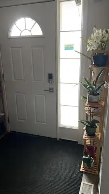 a white door with a window and plants on a shelf at Comfortable room B in Kitchener