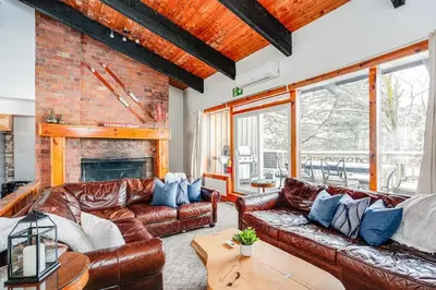 a living room with leather couches and a fireplace at Blue Mtn Chalet with a Sauna, Sleeps 20 in Blue Mountains