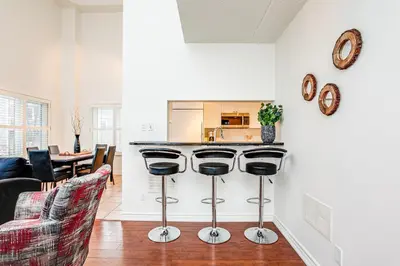 a kitchen and living room with a counter and stools at 3 Bedroom Mountain Walk Condo, Steps to Village in Blue Mountains