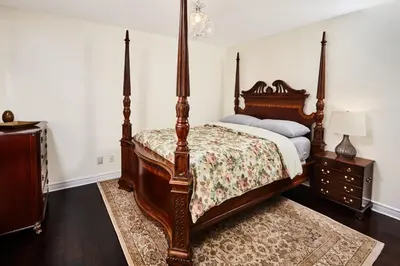 a bedroom with a canopy bed and a dresser at Arrowstone Farmhouse in Historic Old Town in Niagara on the Lake